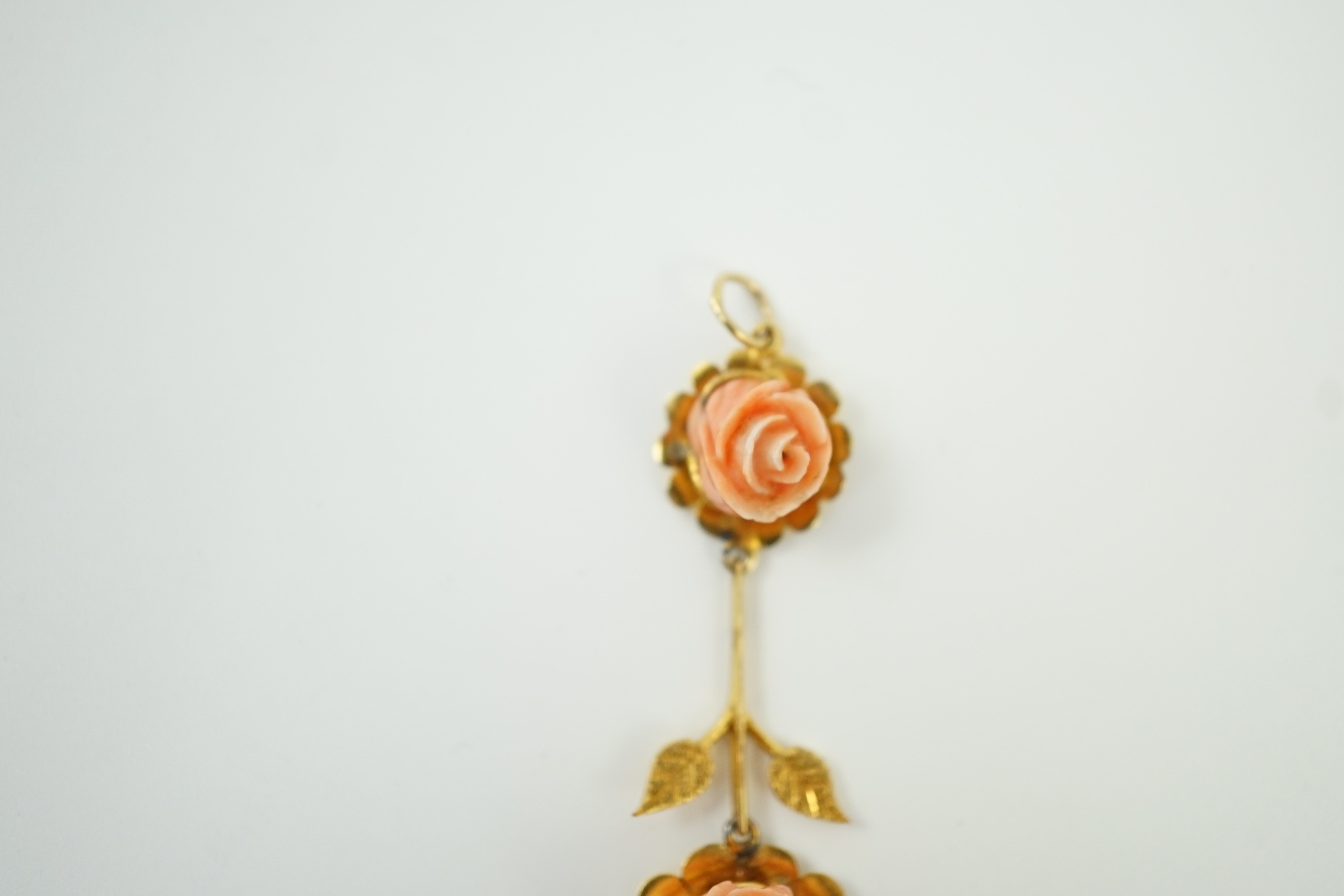 A yellow metal and two stone carved coral set 'rose' drop pendant, overall 57mm, gross weight 6 grams.